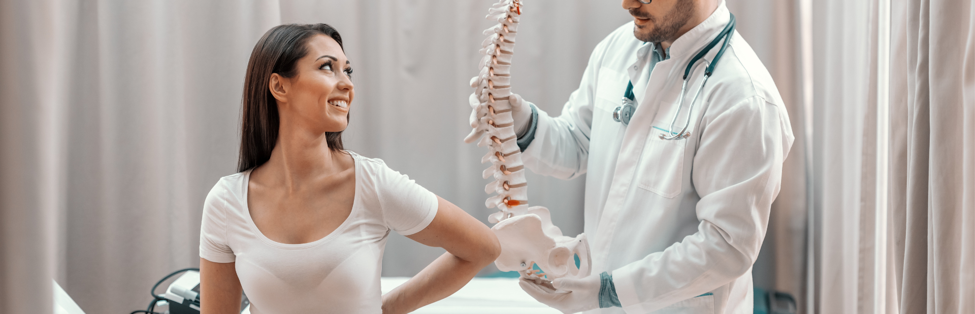mulher sentada na maca do hospital e mostrando a localidade da dor na coluna vertebral